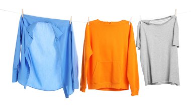 Çamaşır ipini beyaz arka planda tutarken farklı giysiler kuruyor