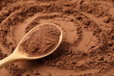 Arkaplan olarak kakao tozu ve tahta kaşık, yakın plan.