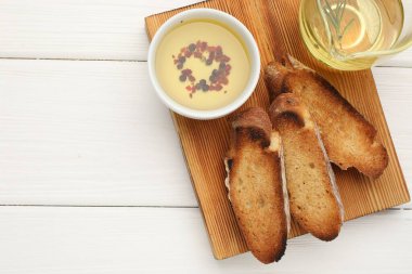 Beyaz ahşap masa üzerinde zeytinyağı ve baharat dilimleri, üst manzara. Metin için boşluk