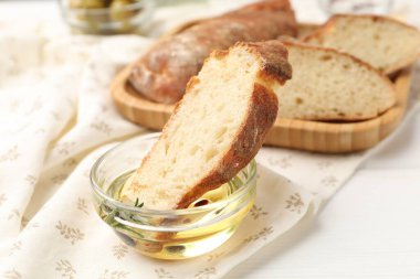 Beyaz ahşap masada zeytinyağlı baget dilimleri, yakın plan.