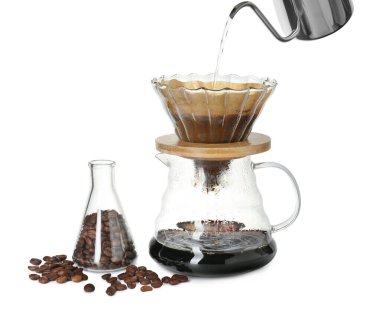 Beyaz arkaplanda filtresi olan cam kimya kahve makinesine sıcak su dökülüyor.