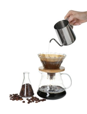 Kadın cam kimya makinesine sıcak su döküyor. Beyaz arka planda filtresi olan kahve makinesi, yakın plan.