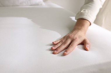 Yatakta yumuşak yatağa dokunan adam, yakın plan.