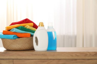 İçerideki ahşap dolapta havlu ve şişe deterjan dolu çamaşır sepeti, mesaj için yer.