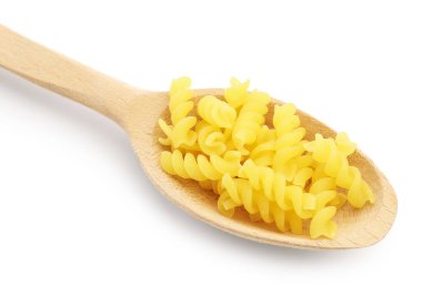Tahta kaşıkta çiğ fusilli makarna. Beyaz kaşıkta izole edilmiş.
