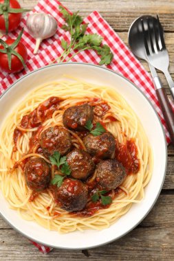 Köfteli lezzetli makarna ahşap masada servis edilir.