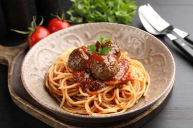 Köfteli lezzetli makarna siyah ahşap masada servis ediliyor, yakın plan.