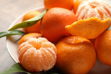 Taze mandalina ve yeşil yapraklar masada, yakın plan.