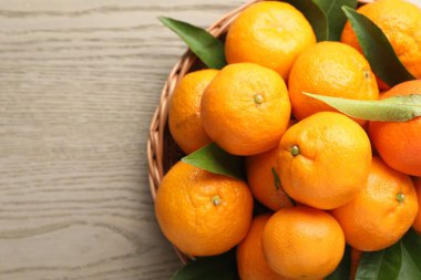 Taze mandalinalar ve ahşap masa üzerinde yeşil yapraklar, üst manzara. Metin için boşluk