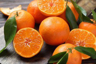 Taze mandalina ve yeşil yapraklar masada, yakın plan.