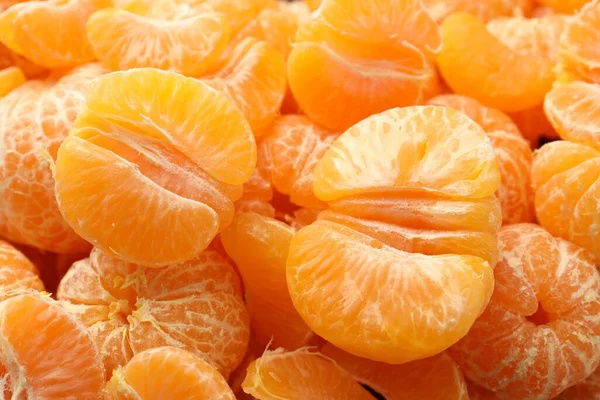 Arka plan olarak birçok olgun soyulmuş mandalina, üst görünüm