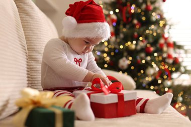 Noel Baba şapkalı şirin bir bebek ve evinde Noel hediyeleri var. Metin için boşluk