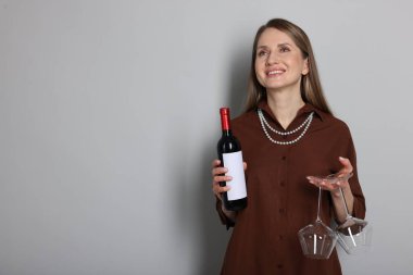 Açık gri arka planda şarap ve gözlüklü profesyonel şarap garsonu. Metin için boşluk