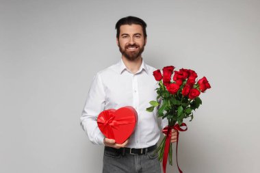 Sevgililer Günü. Bir buket gül ve açık arkaplanda bir hediye.