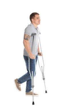 Beyaz arkaplanda koltuk değneği olan bir adam