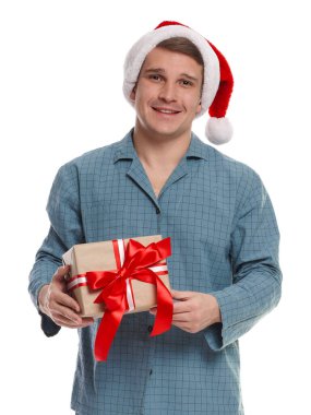 Noel Baba şapkalı ve pijamalı mutlu bir adam.