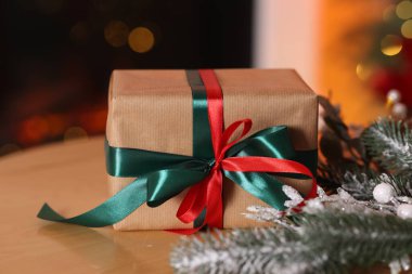 Güzel bir Noel hediyesi ve ahşap masa üzerinde şenlikli bir dekor, yakın plan. Bokeh etkisi