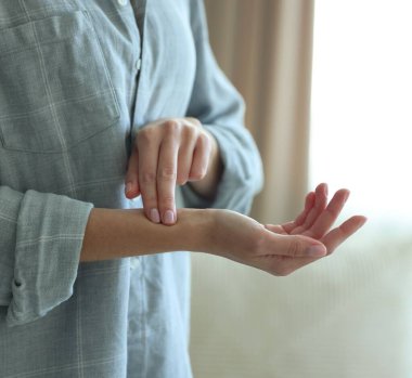 Kadın nabzını içeride kontrol ediyor, yakın plan.