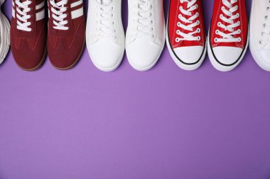 Mor arka planda farklı şık spor ayakkabılar, düz yatış. Metin için boşluk