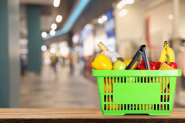 Süpermarketteki ürünlerle dolu bir alışveriş sepeti. Metin için boşluk