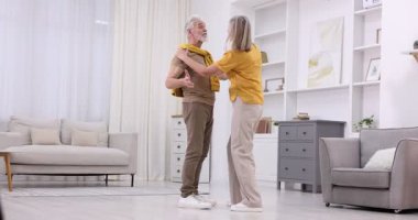 Güzel yaşlı çift evde dans ediyor.