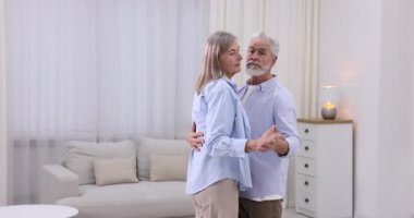 Güzel yaşlı çift evde dans ediyor.