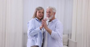 Güzel yaşlı çift evde dans ediyor.
