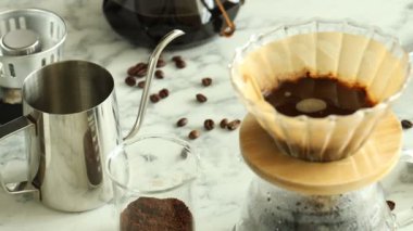 Beyaz mermer masada kağıt filtreli kimya kahve makinesinde aromatik kahve yapmak, yakın plan. Kamera sağa hareket ediyor