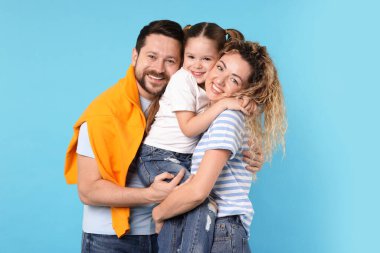 Açık mavi arka planda kucaklaşan mutlu aile portresi
