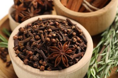 Tabaklardaki farklı baharatlar ve masadaki sıcak şarap için taze biberiye.