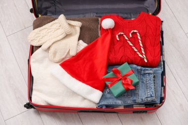 Noel tatili. İçinde Noel Baba şapkası, giysi, baston şeker ve hediye kutusu olan çanta.