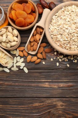 Tahıl yapıyorum. Yulaf gevreği, kurutulmuş meyve ve ahşap masa üzerindeki diğer malzemeler, düz yatak. Metin için boşluk