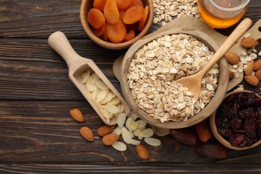 Tahıl yapıyorum. Yulaf gevreği, kurutulmuş meyve ve diğer malzemeler ahşap masada, düz yerde.