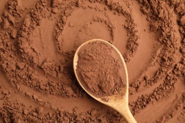 Kakao tozu ve tahta kaşık arka plan olarak, üst görünüm