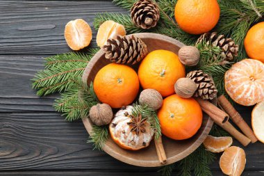 Olgun mandalinalar, baharatlar, cevizler, köknar ağacı dalları ve kozalaklar ahşap masa üzerinde, düz yatıyordu.