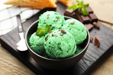 Ahşap masada servis edilen naneli çikolatalı dondurma.