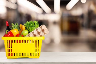 Süpermarketteki ürünlerle dolu bir alışveriş sepeti. Metin için boşluk