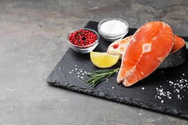 Baharatlı ve limonlu somon filetosu ve gri desenli masa. Metin için boşluk