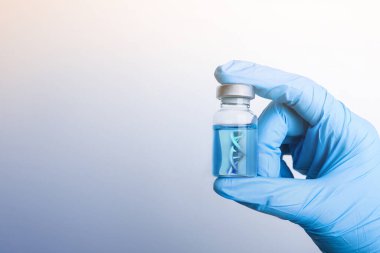 Aşı ve DNA iplikçikleri olan bir bilim adamı gri gradyan arka planda, yakın plan...