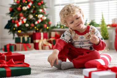 Noel hediyeleri ve dekoratif şeker kamışlı şirin bir bebek. Şenlikli bir odada, mesaj atmak için yer var.