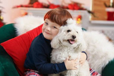 Noel için dekore edilmiş, şirin köpeğiyle küçük bir çocuk.
