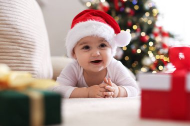 Evdeki kanepede Noel Baba şapkalı şirin bir bebek var. Noel sezonu