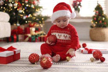 Noel Baba şapkalı şirin bir bebek, süsler ve evde hediye, mesaj için yer. Noel sezonu