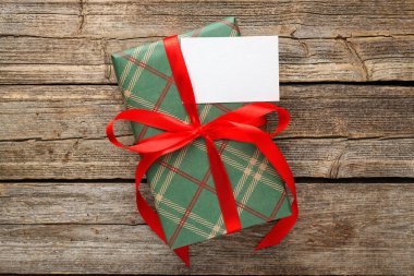 Tahta masanın üstünde boş bir kartın olduğu güzel bir hediye kutusu.