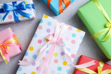 Gri masada güzel paketlenmiş hediyeler, düz uzanmış