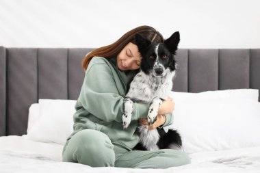 Evde yatağında Collie köpeği olan bir kadın.