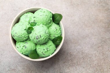 Gri masadaki kasede nefis naneli çikolatalı dondurma, üst manzara. Metin için boşluk