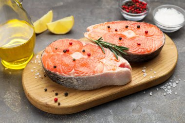 Baharatlı, limonlu ve yağlı somon filetosu. Gri desenli masa, yakın plan.