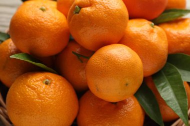 Taze mandalina ve yeşil yapraklar masada, yakın plan.