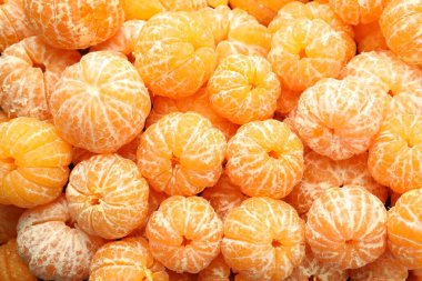 Arka plan olarak birçok olgun soyulmuş mandalina, üst görünüm